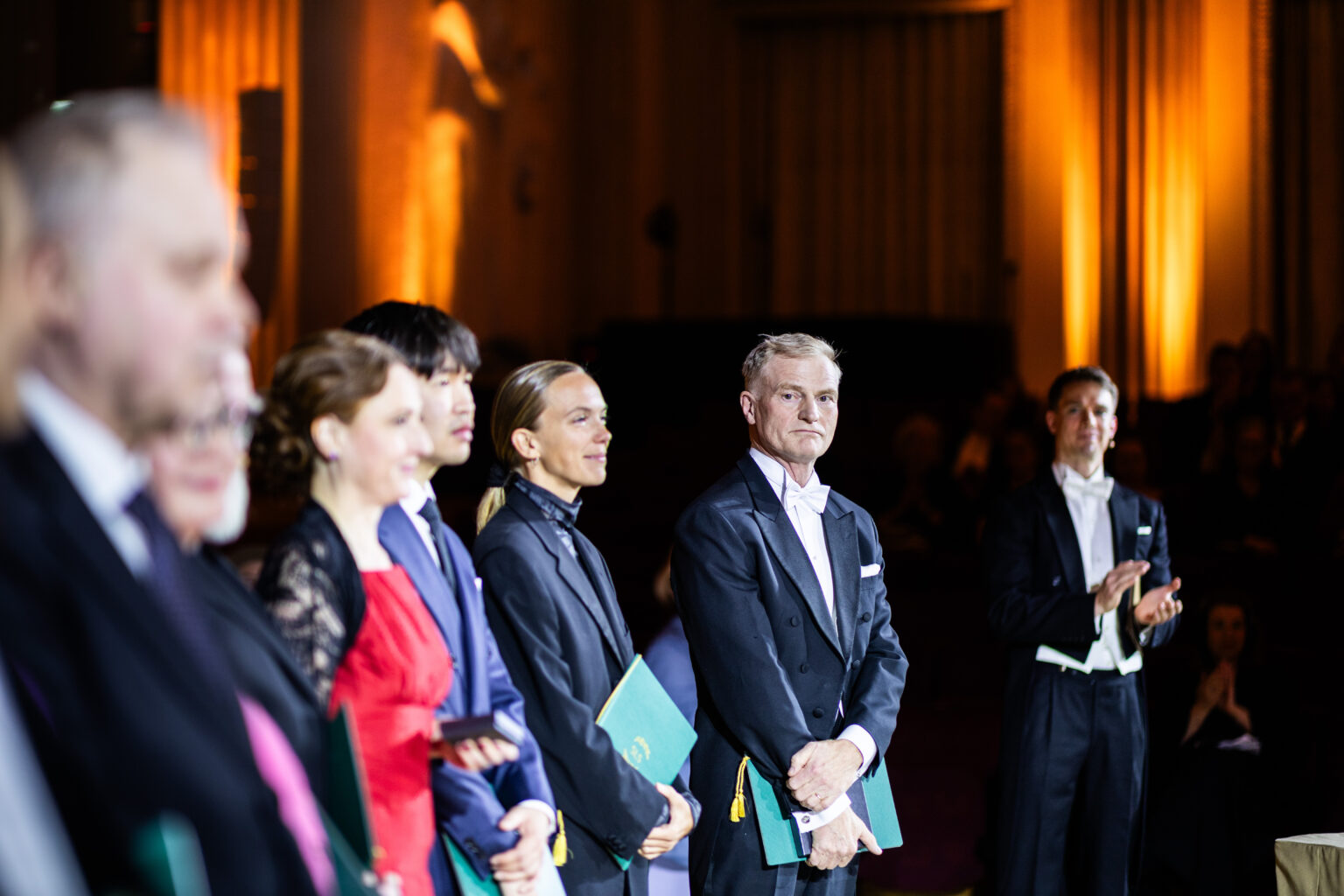 Fyra personer står på en scen med diplom i handen