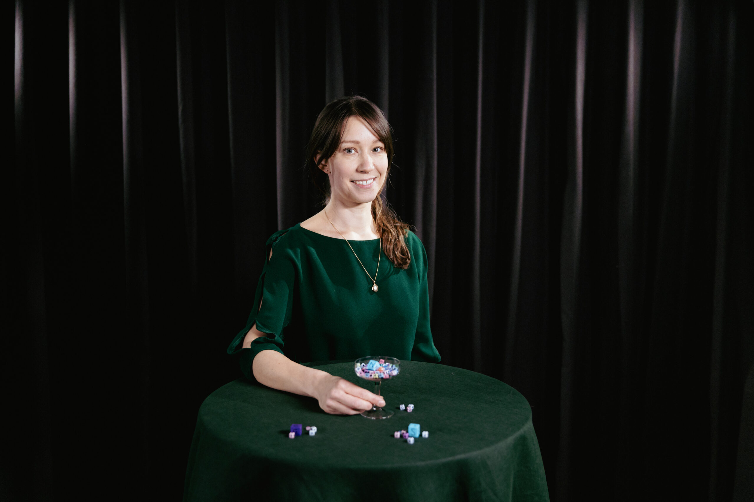 Kvinna med ett glas fyllt med leksakstärningar med bokstäver