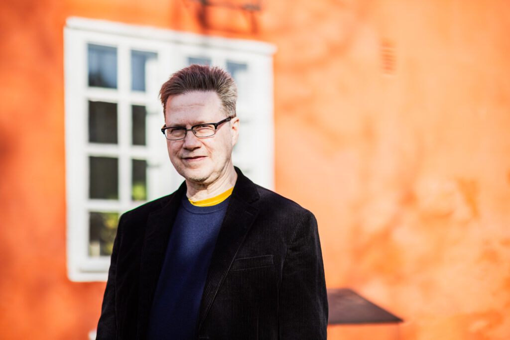 person utanför en röd byggnad