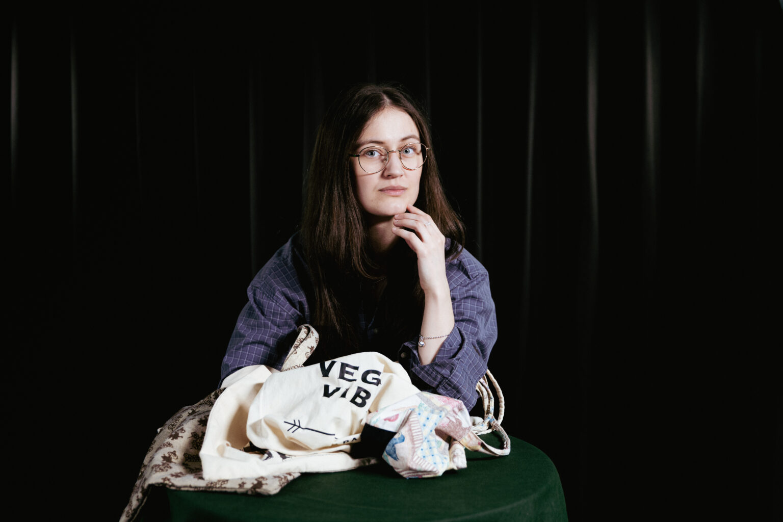 kvinna med en hög tygkassar framför sig